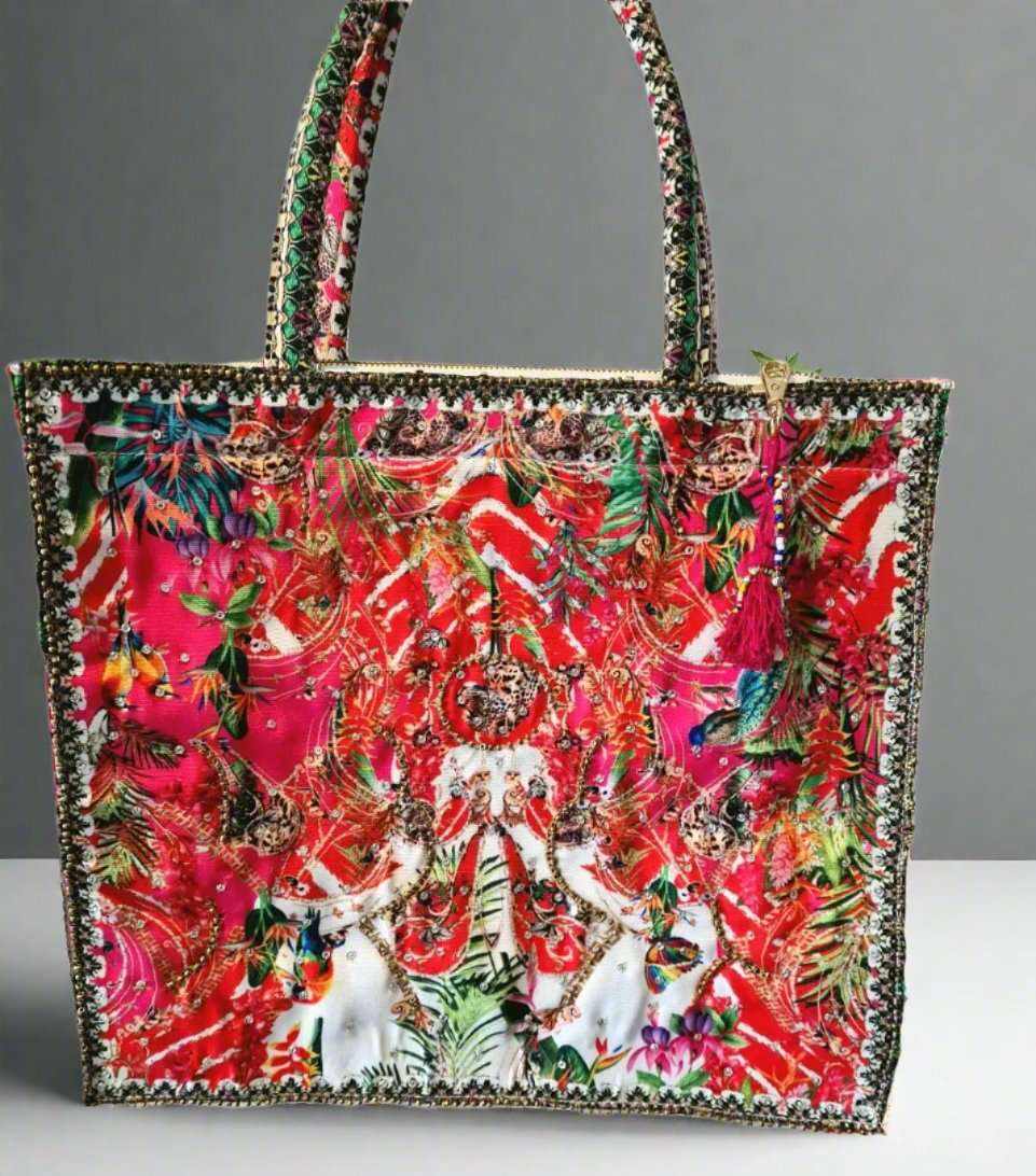 Large embellished tote bag with vibrant floral and animal print, padded handles, and zipper closure