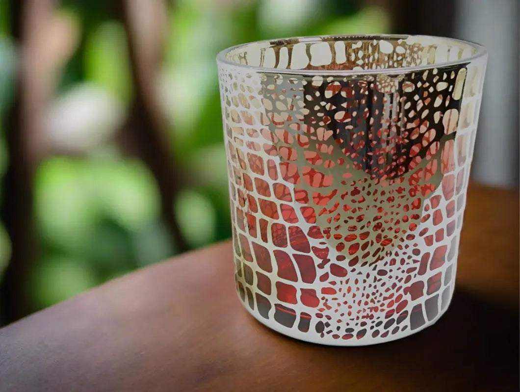 Red Gold Croc Print deluxe soy candle in cut glass jar on wooden surface with blurred green background