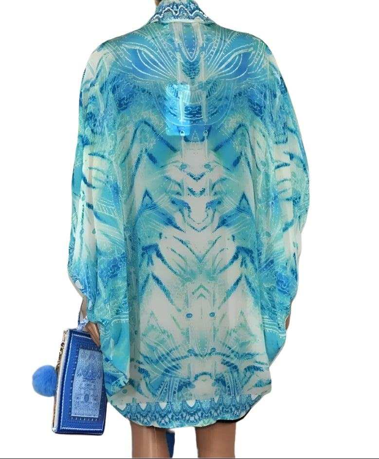blue Tahitian silk cape cover-up with intricate print and rounded hemline worn over swimsuit