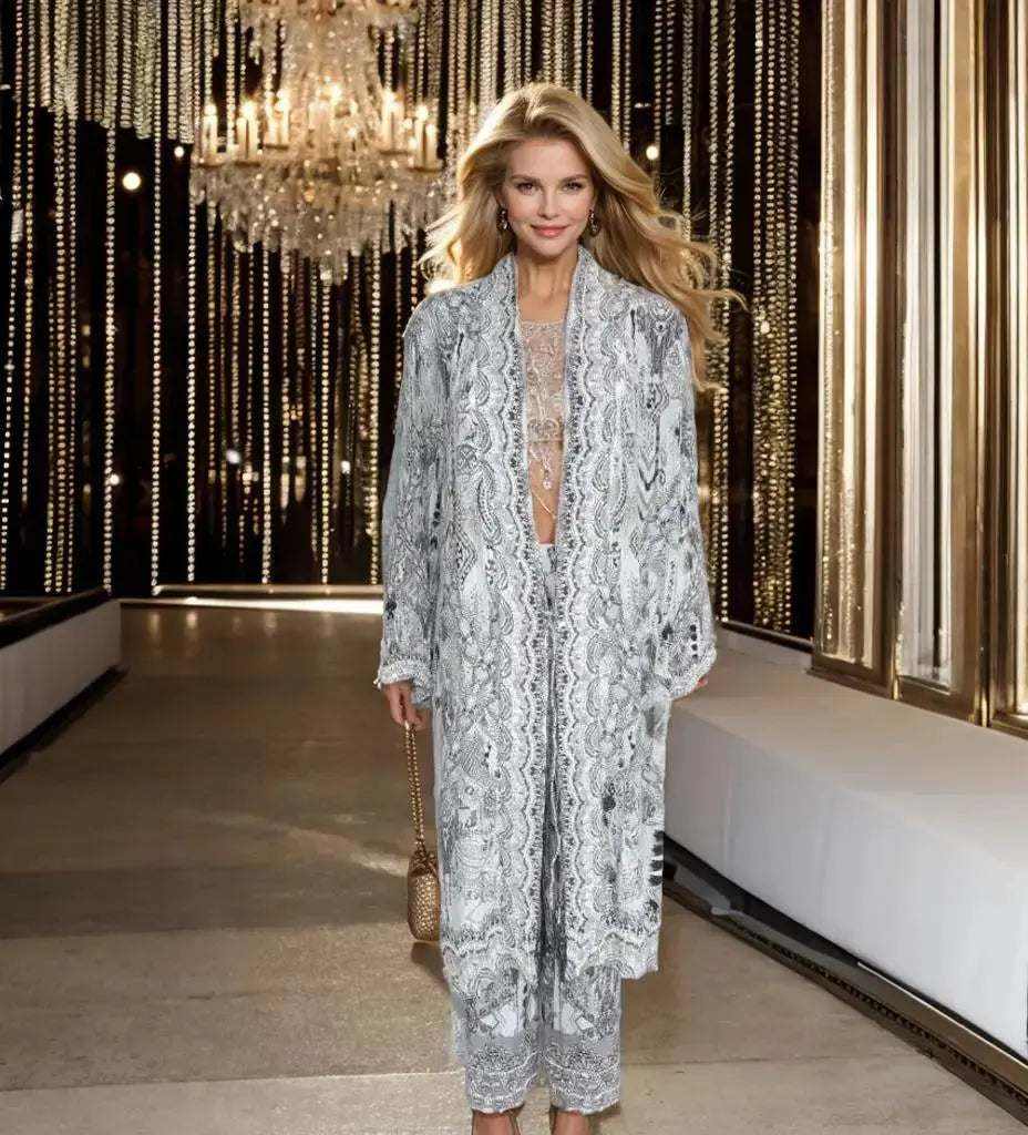 Woman wearing soft grey silk embellished palazzo pants with matching kimono jacket in a luxurious setting