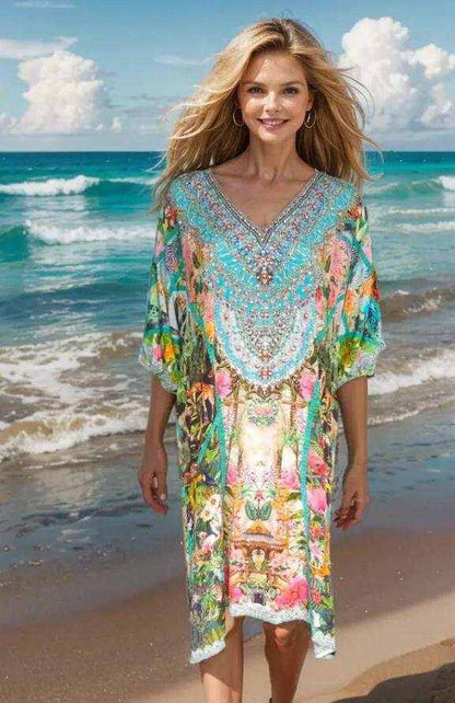 Woman wearing a colorful jungle sleeve embellished dress with V-neck and handsewn beadwork at the beach