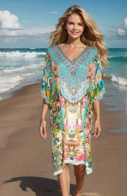 Woman walking on beach wearing colorful jungle sleeve embellished dress with V-neck and handsewn beadwork
