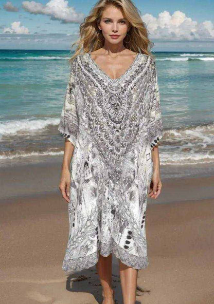 Woman wearing 34 sleeve silk embellished dress with beadwork standing on beach