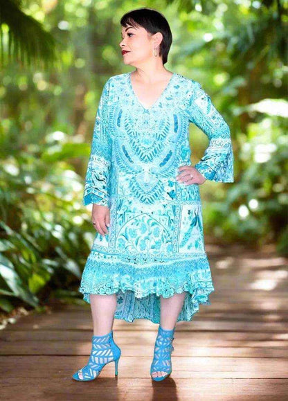 Silk hi-low frill dress in peacock blue with hand-sewn beadwork and V-neck worn by woman outdoors
