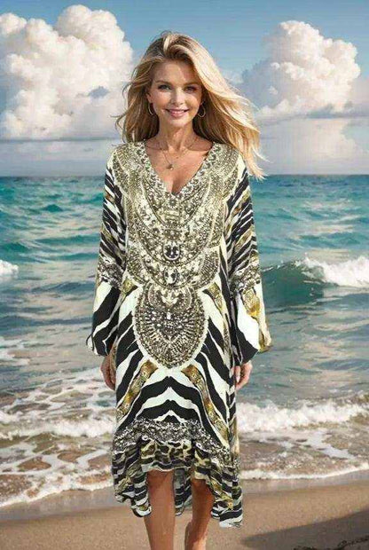 Woman wearing animal print silk hi-low frill dress with handsewn gold and silver beadwork by the ocean