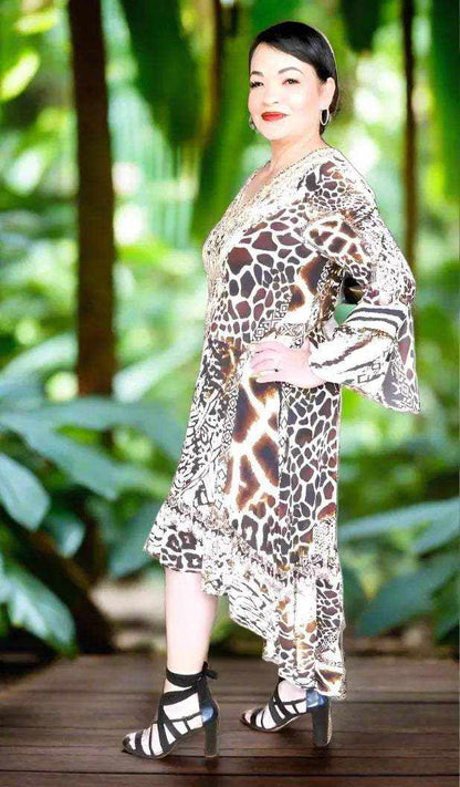 Woman wearing Silk Hi-Low Frill Dress with animal print, handsewn beadwork, and long split sleeves outdoors