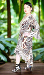 Woman wearing Silk Hi-Low Frill Dress with animal print, handsewn beadwork, and long split sleeves outdoors