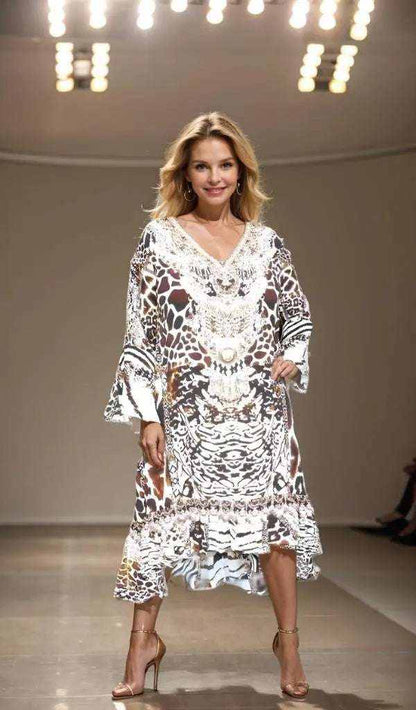 Woman wearing animal print Silk Hi-Low Frill Dress with handsewn beadwork and long split sleeves on runway