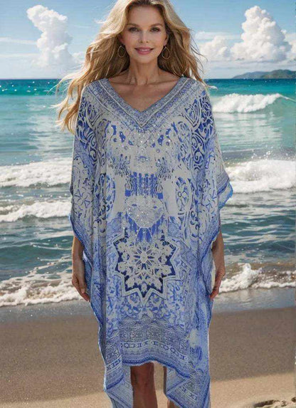 Woman wearing blue and white Garden Short Silk Embellished Kaftan with handsewn beadwork on beach background