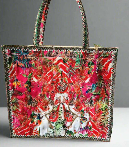 Large embellished tote bag with vibrant floral and animal print, padded handles, and zipper closure