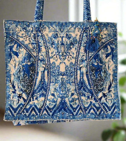 Large embellished tote bag with blue intricate digital print, padded handles, and zipper closure.