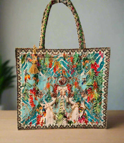 Large embellished tote bag with colorful floral print, padded handles, zipper closure, and decorative tassel by Fashion Spectrum