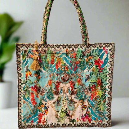 Large embellished tote bag with vibrant floral and animal print, padded handles, and zipper closure