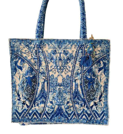 Blue and white patterned tote bag with tassel detail.