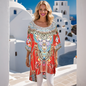 Woman wearing red silk kaftan with embellishments and white capri pants. Hi-low kaftan top.