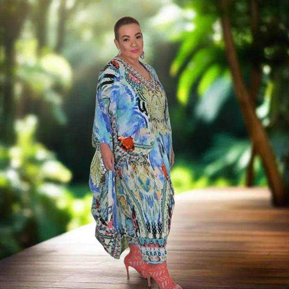 woman wearing colorful Paradise Blue Silk Harem Pants with beadwork and floral print in tropical setting