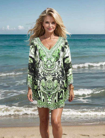 Woman wearing Garbo Green silk embellished butterfly top with beadwork standing on beach by the sea