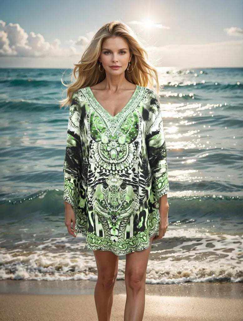 Woman wearing silk embellished butterfly top in garbo green standing by the ocean shore