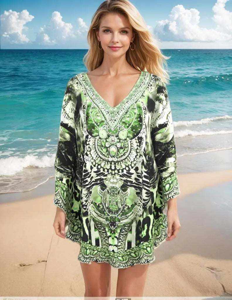 Woman wearing Garbo Green silk embellished butterfly top with beadwork on a beach background
