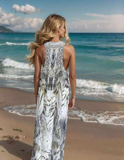 Back view of woman wearing Tahiti Dream Silk Maxi Dress with hand-embellished racerback on sandy beach by ocean