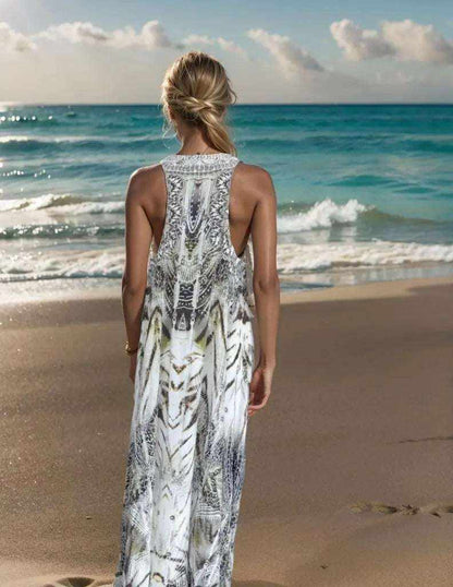 Back view of a woman wearing the Tahiti Dream Silk Maxi Dress with hand-embellished racerback standing on a beach at sunset