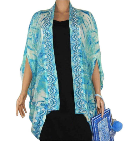 blue and white silk cape cover-up with Tahitian print and beadwork worn over black dress