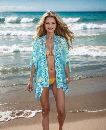 woman wearing blue silk cape cover-up on beach over yellow bikini