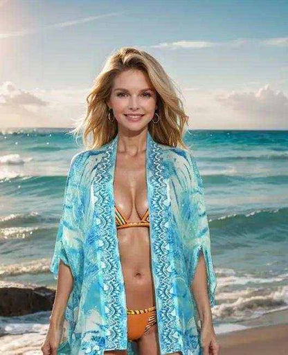 woman wearing blue silk cape cover-up on beach over bikini