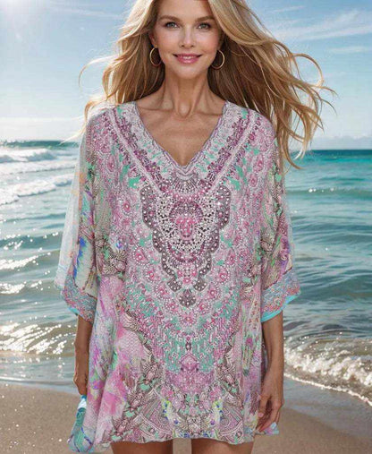 Zahara Silk Batwing Kaftan Top with hand-embellished beadwork in pastel colors worn by woman on beach