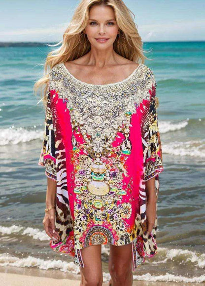 Woman wearing red silk kaftan batwing top with hand-embellished beadwork on the beach