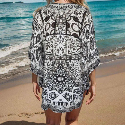Back view of Silk Embellished Butterfly Top with geometric black and white print and loose fit on beach model