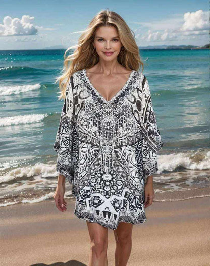 Woman wearing black and white silk embellished butterfly top with geometric and snake print at the beach