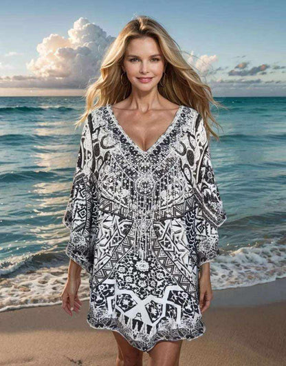 Woman wearing black and white Silk Embellished Butterfly Top with geometric print and handsewn beadwork by the sea