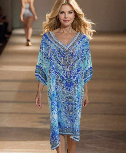 Woman wearing 3/4 sleeve silk embellished dress in Egyptian blue with intricate beadwork and V-neck design walking on runway