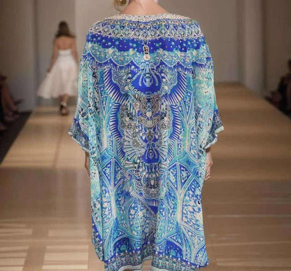 Blue silk kaftan with Egyptian-inspired print and embellishments, back view on runway.