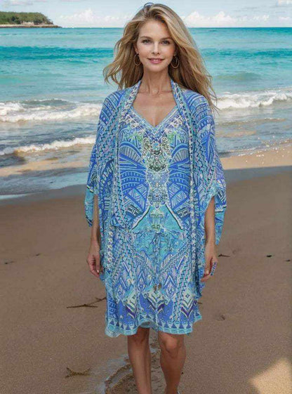 Woman wearing blue short silk embellished kaftan geo with geometric patterns and hand-sewn embellishments on the beach