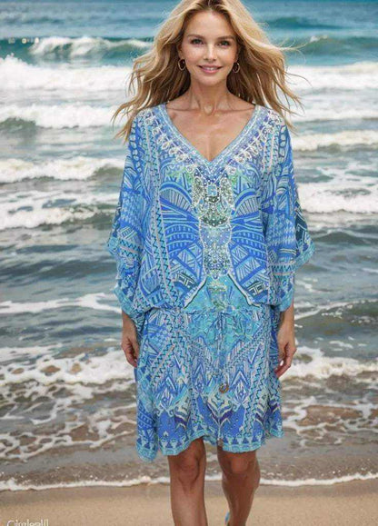 Woman wearing blue short silk embellished kaftan geo with geometric patterns on the beach