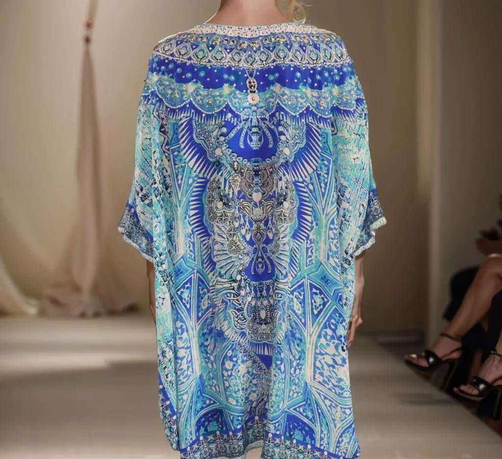 Blue embellished silk kaftan with Egyptian-inspired print, hi-low hem.