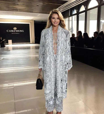 woman wearing silk embellished palazzo pants and matching kimono jacket walking at fashion show