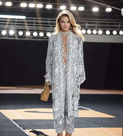 Woman wearing silver silk embellished palazzo pants and matching kimono jacket on runway