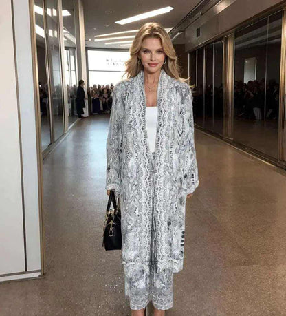 Woman wearing soft grey and black silk embellished palazzo pants with matching kimono jacket on runway