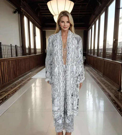 Woman wearing soft grey silk embellished palazzo pants with matching kimono jacket in elegant hallway