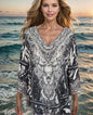 Silk Embellished Butterfly Top with animal print and intricate beadwork, V-neck and rounded hemline, modeled by a woman on the beach at sunset