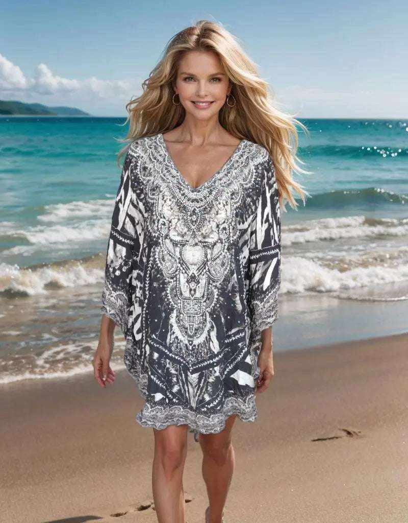 Woman wearing silk embellished butterfly top with animal print and beadwork on beach