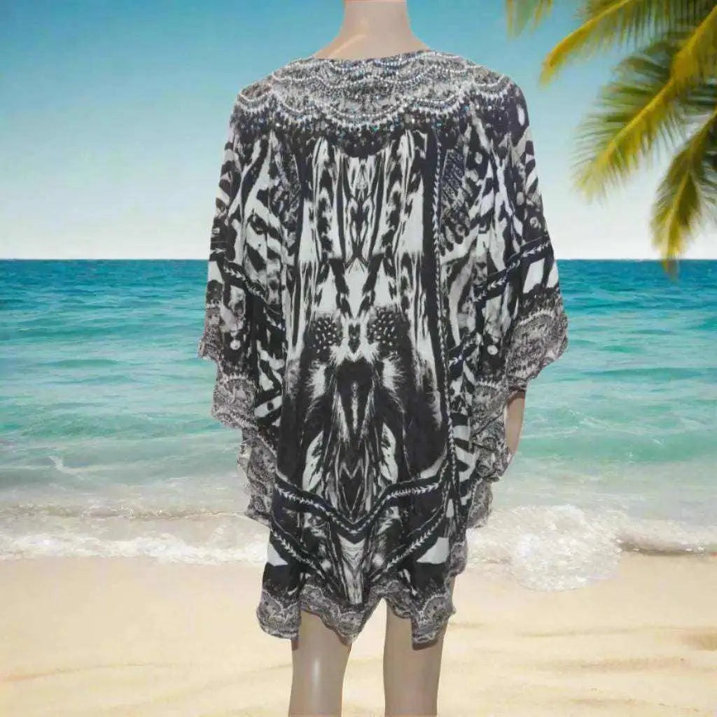 Silk Embellished Butterfly Top with animal print and handsewn beadwork displayed on beach background