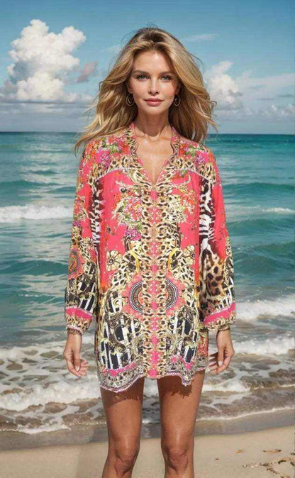Woman wearing Garden Delight red silk embellished shirt with animal print standing on beach