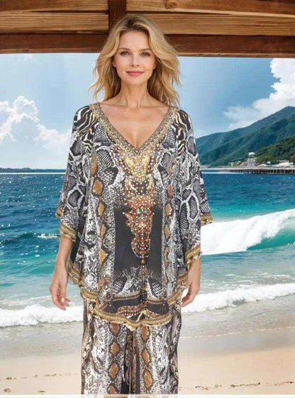 Woman wearing a snake print Silk Embellished Butterfly Top with handsewn beadwork and V-neck at the beach