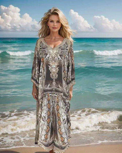 Woman wearing silk embellished wrap pants with beadwork and cobra print standing by the ocean