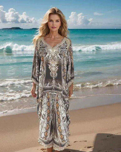 Woman wearing silk embellished wrap pants with cobra snake print and beadwork on a beach background