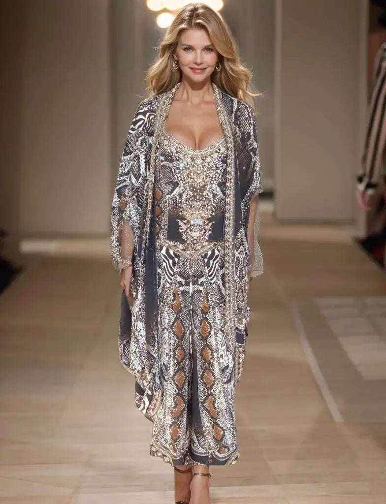 Model wearing silk embellished wrap pants with handsewn beadwork and cobra snake print on runway